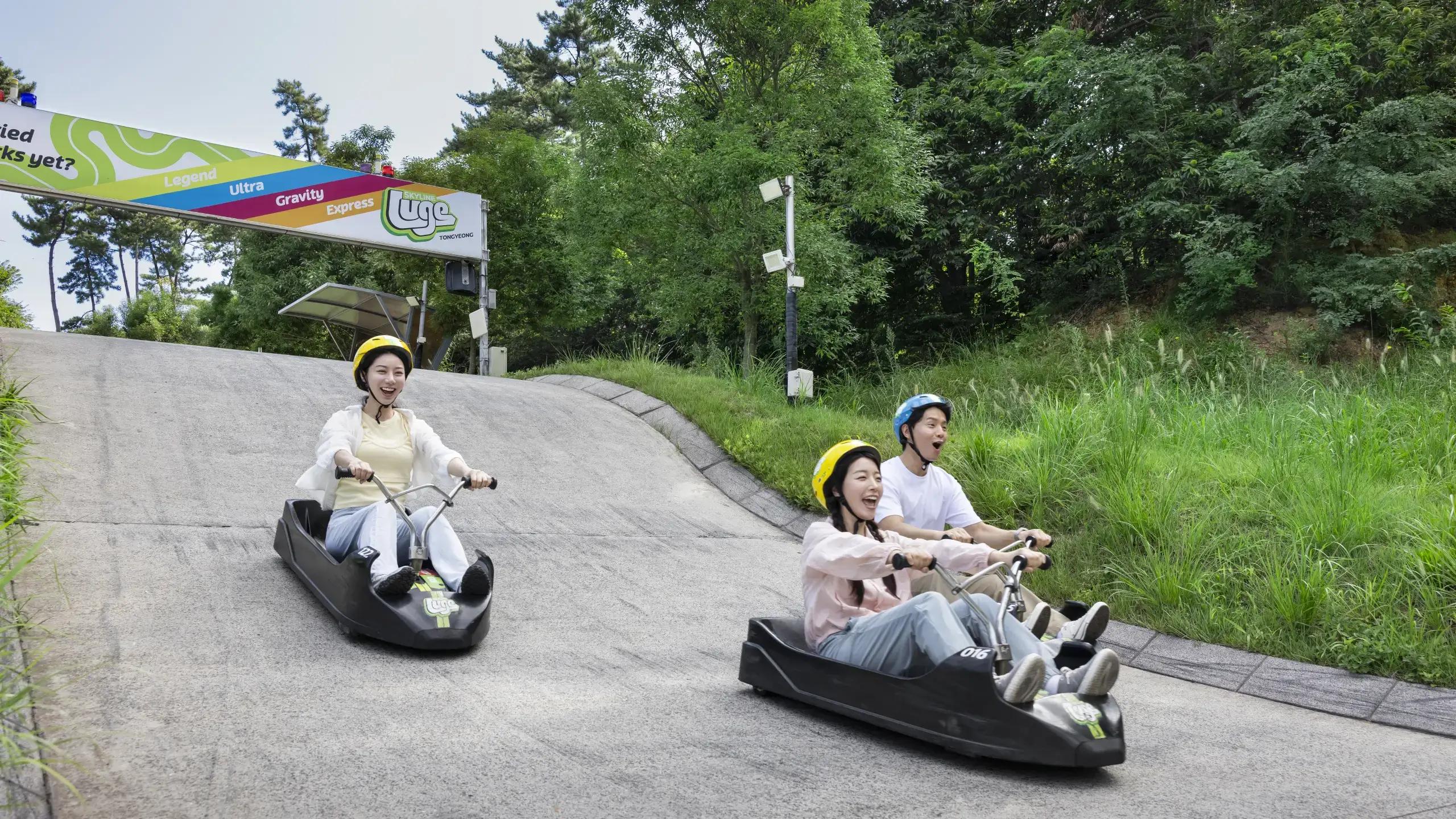 Friends enjoying a fun ride together on the Skyline Luge Tongyeong track.