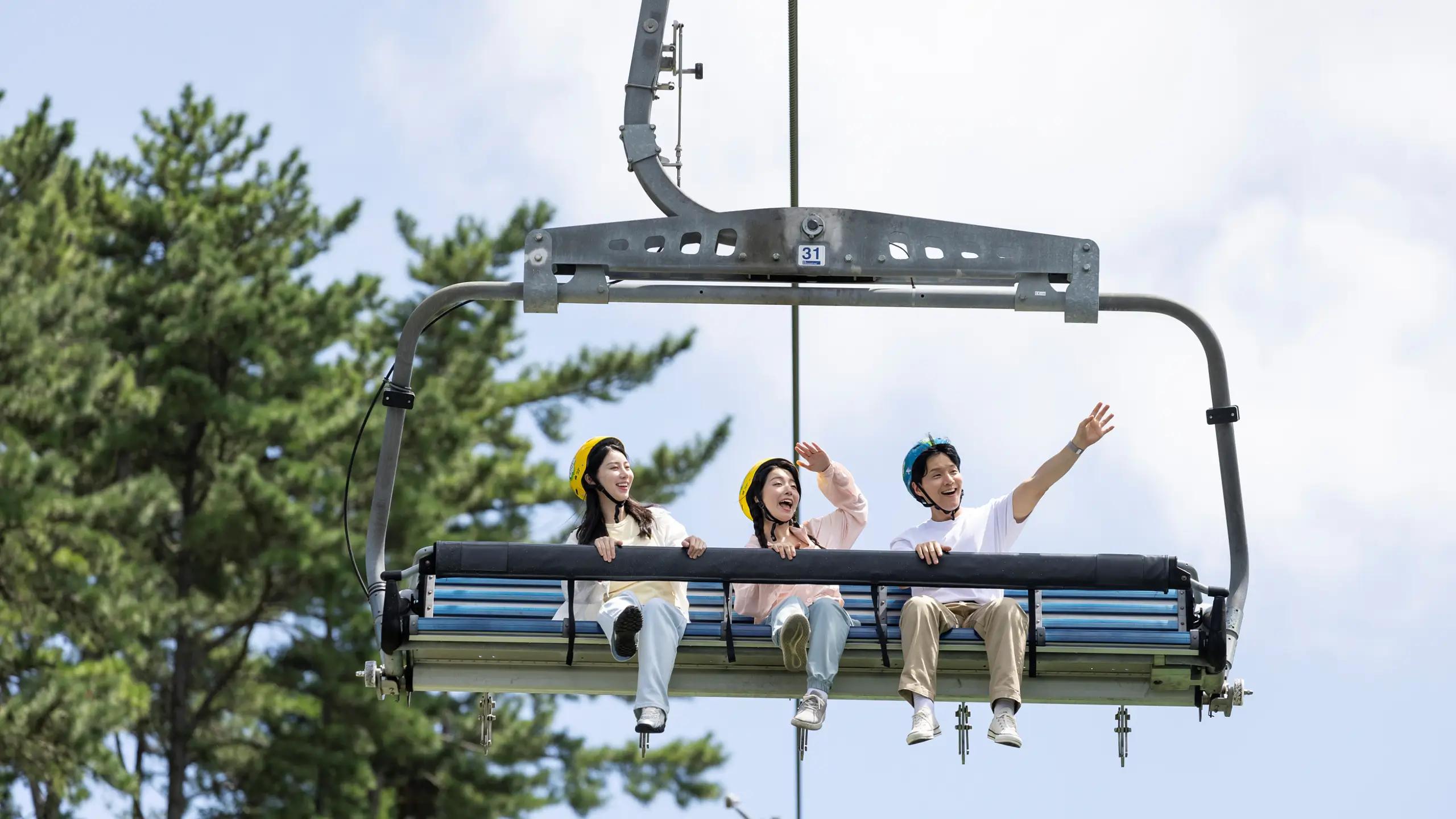 Smiling riders taking in the views on the Skyride at Skyline Luge Tongyeong.