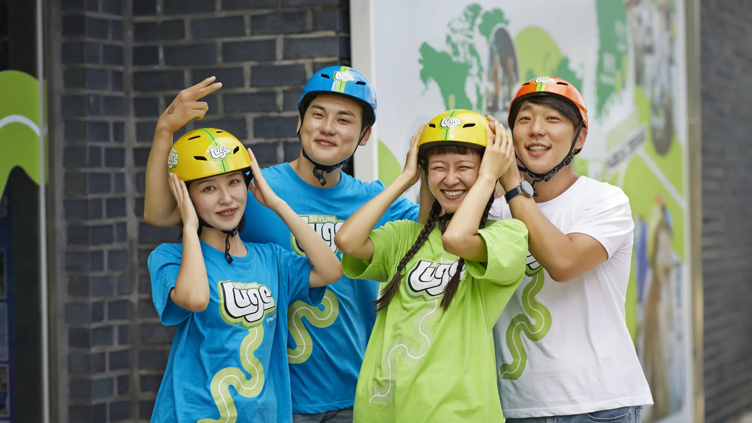 A group enjoying a fun team activity at Skyline Luge Tongyeong, getting ready for their ride together in helmets.