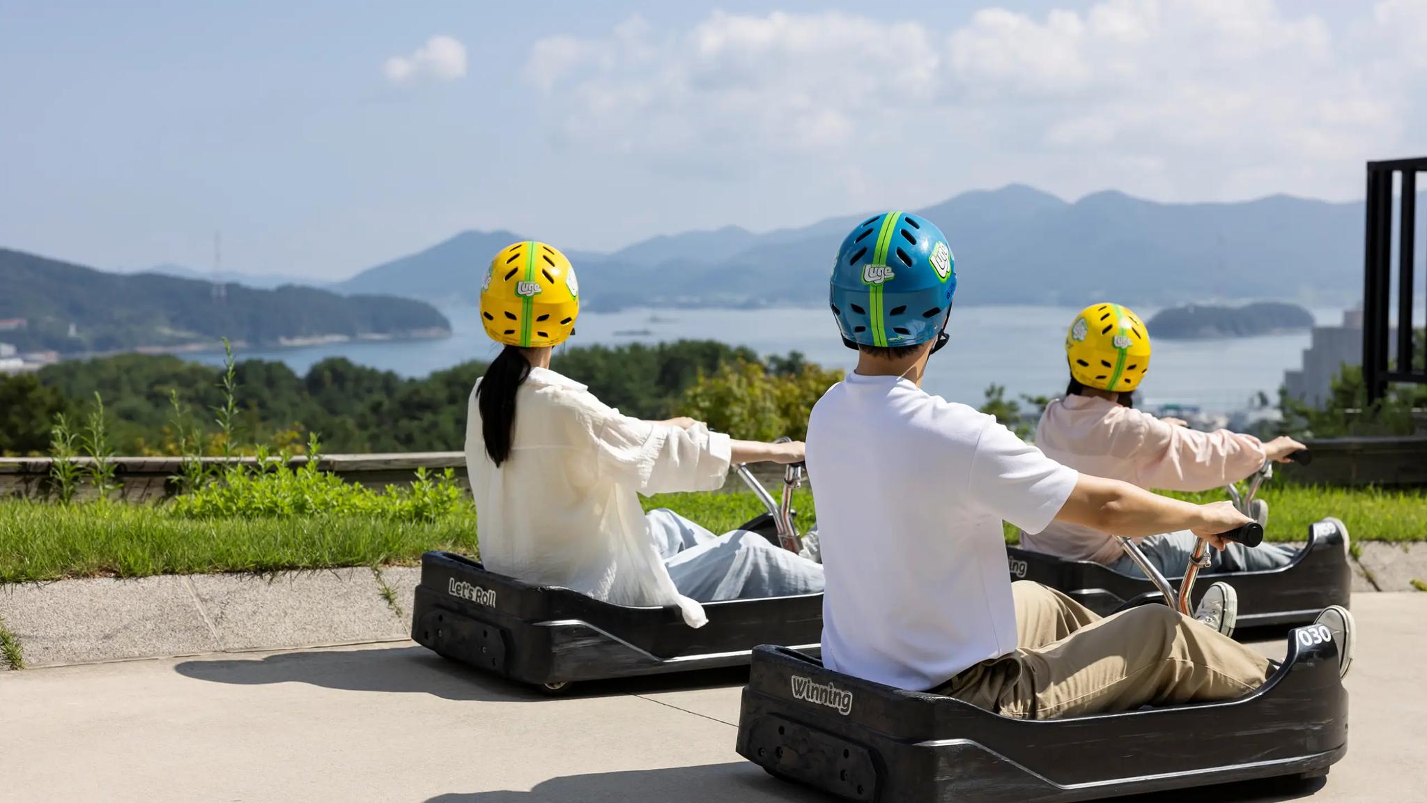 Luge riders enjoying the scenic views at Skyline Luge Tongyeong.