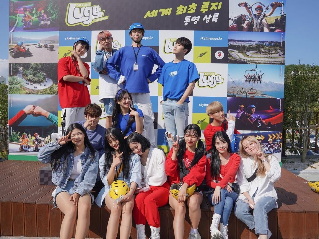 A large group of people pose for a photo on the Luge podium.