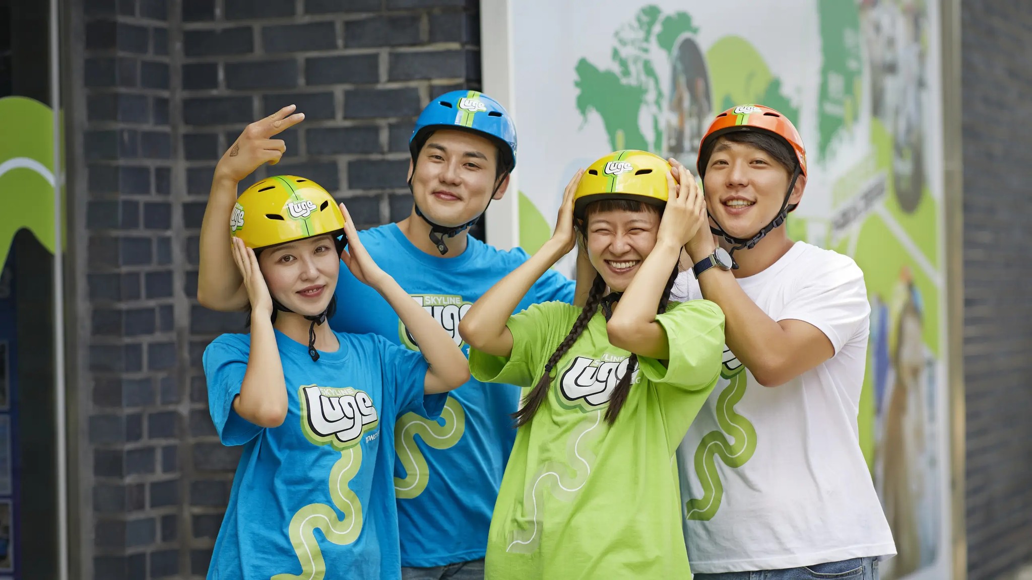 A group enjoying a fun team activity at Skyline Luge Tongyeong, getting ready for their ride together in helmets.